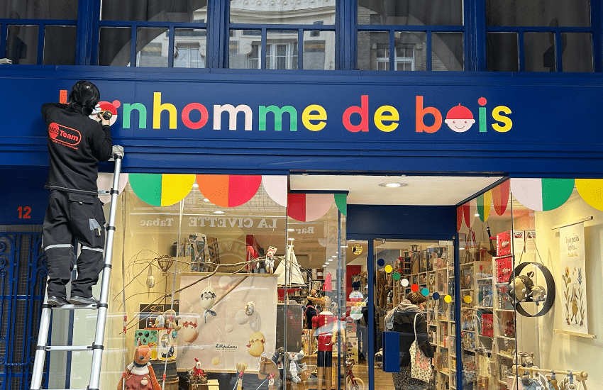 Pose d'une enseigne personnalisée sur uneboutique de jouets